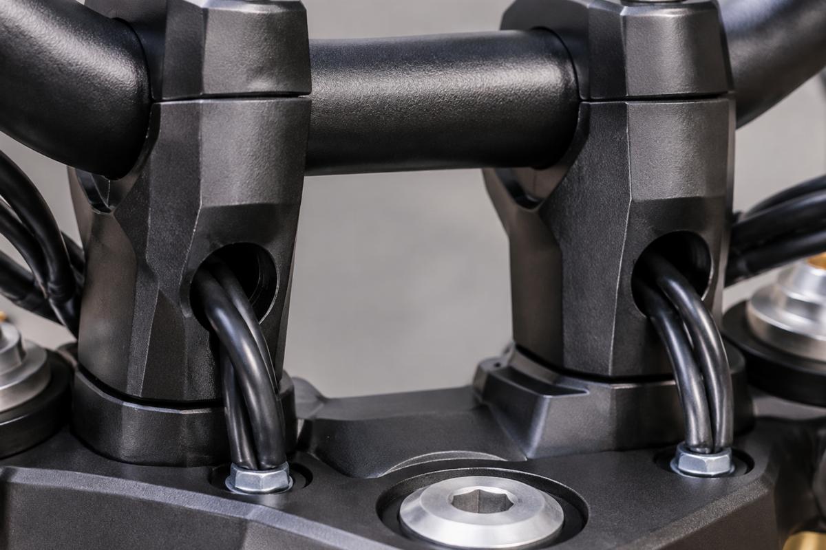 Close-up detail of the drilled internal wiring holes on the handlebar riser area
