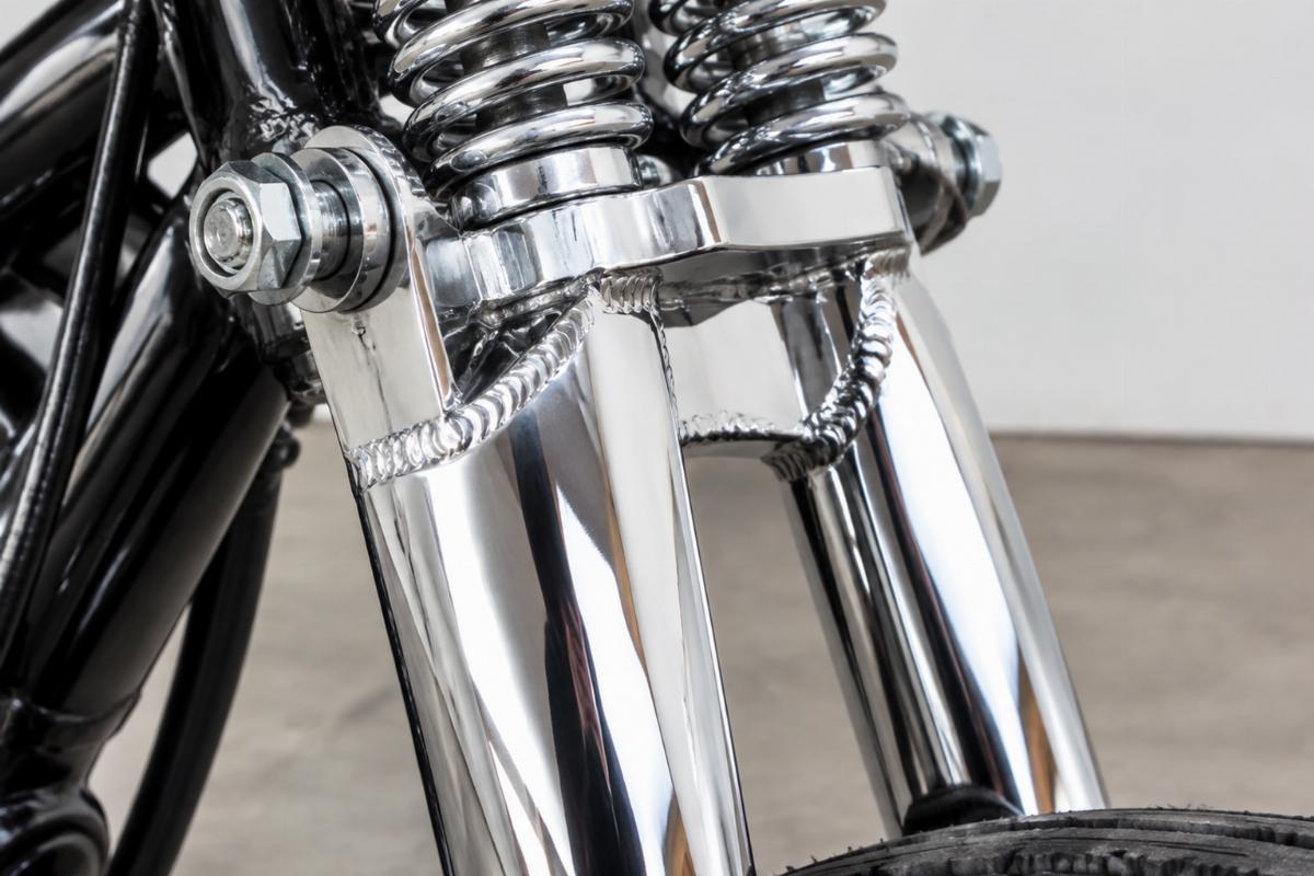 Close-up of a newly manufactured springer front end leg showing weld quality and chrome finish