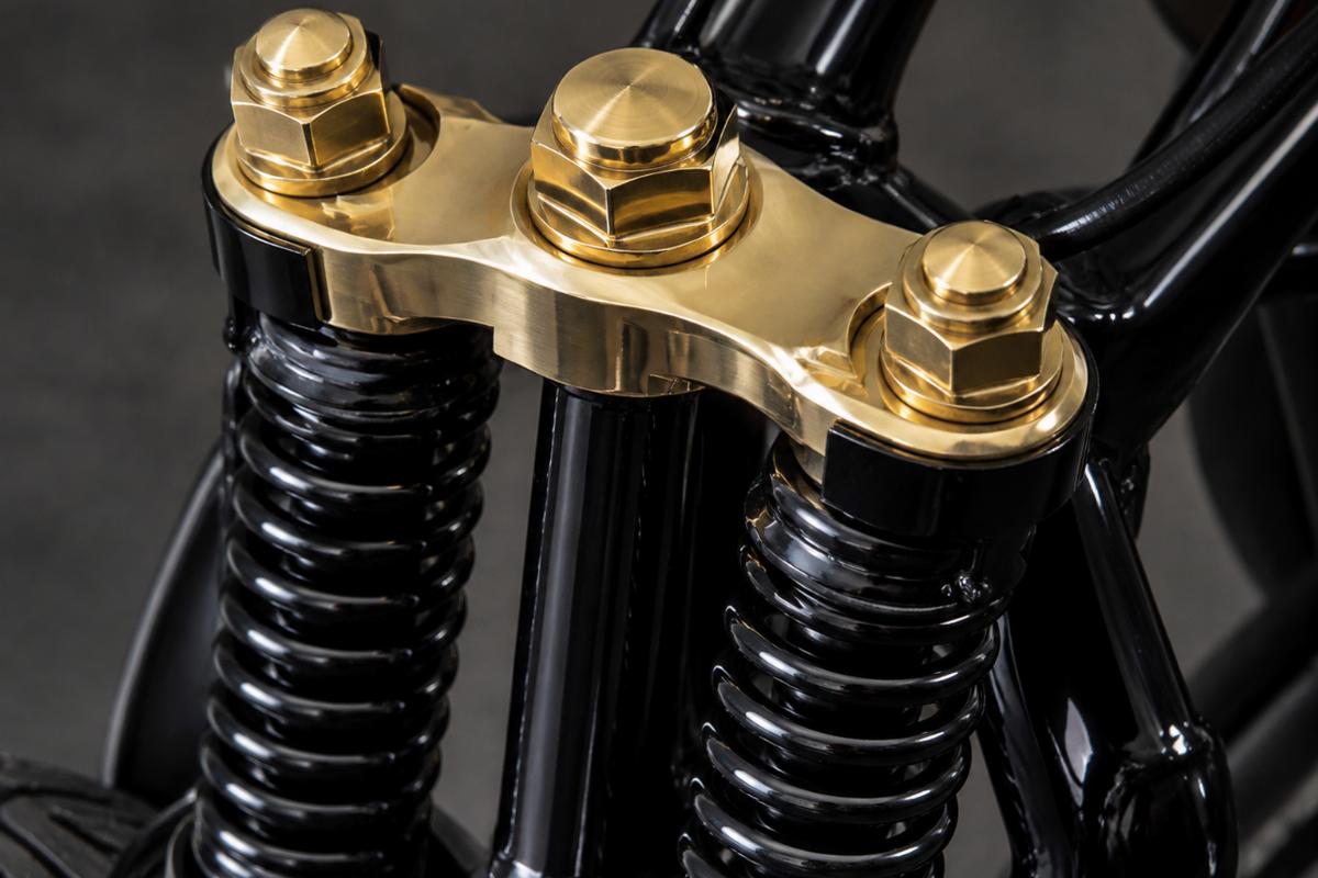 Close up of brass plated top tree and axle nuts on black 24 inch springer fork