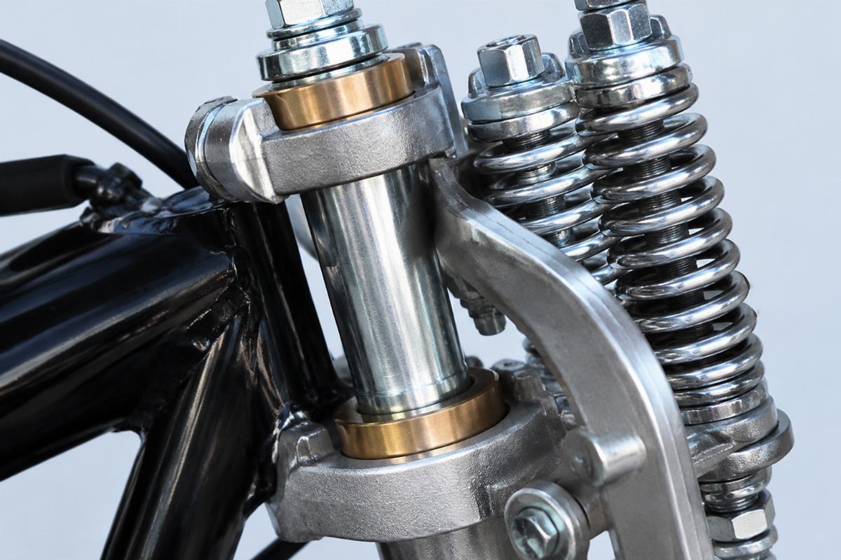 Close up of bronze rocker bushings and zinc plated steering stem on custom springer