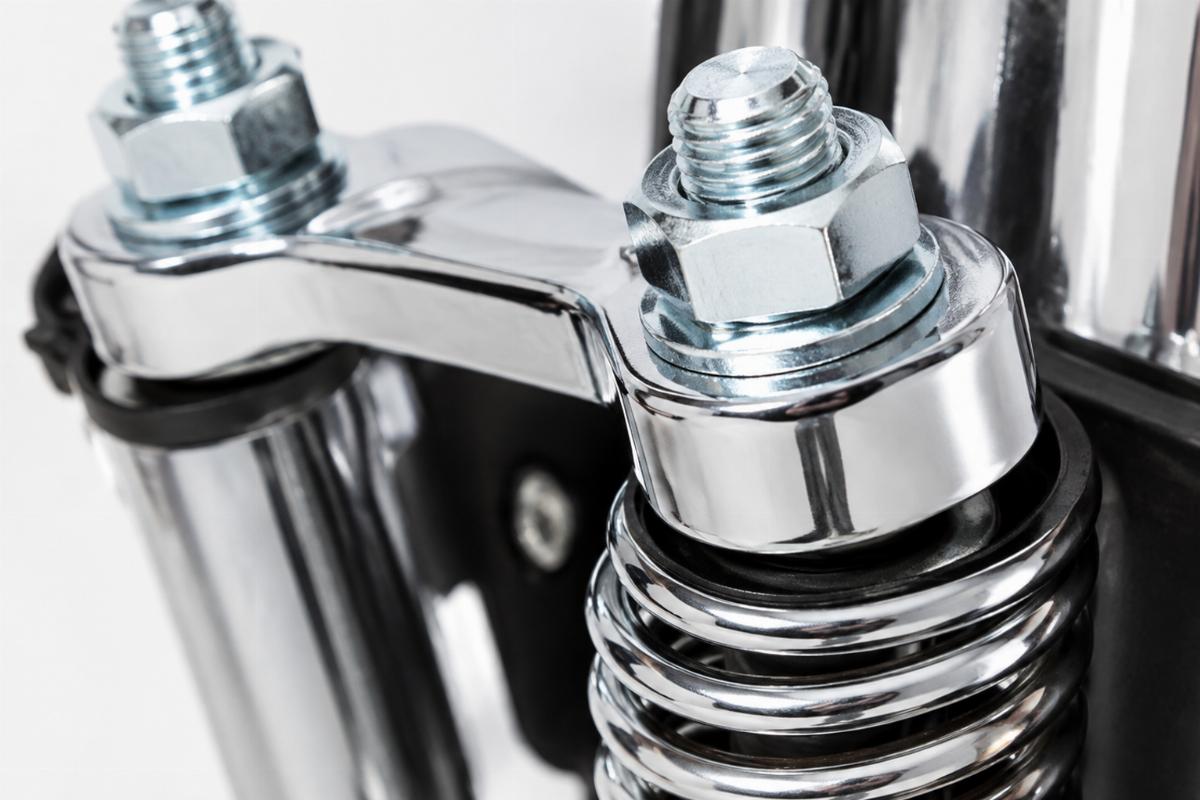Close up of chrome finish and zinc plated rocker studs on inline spring fork