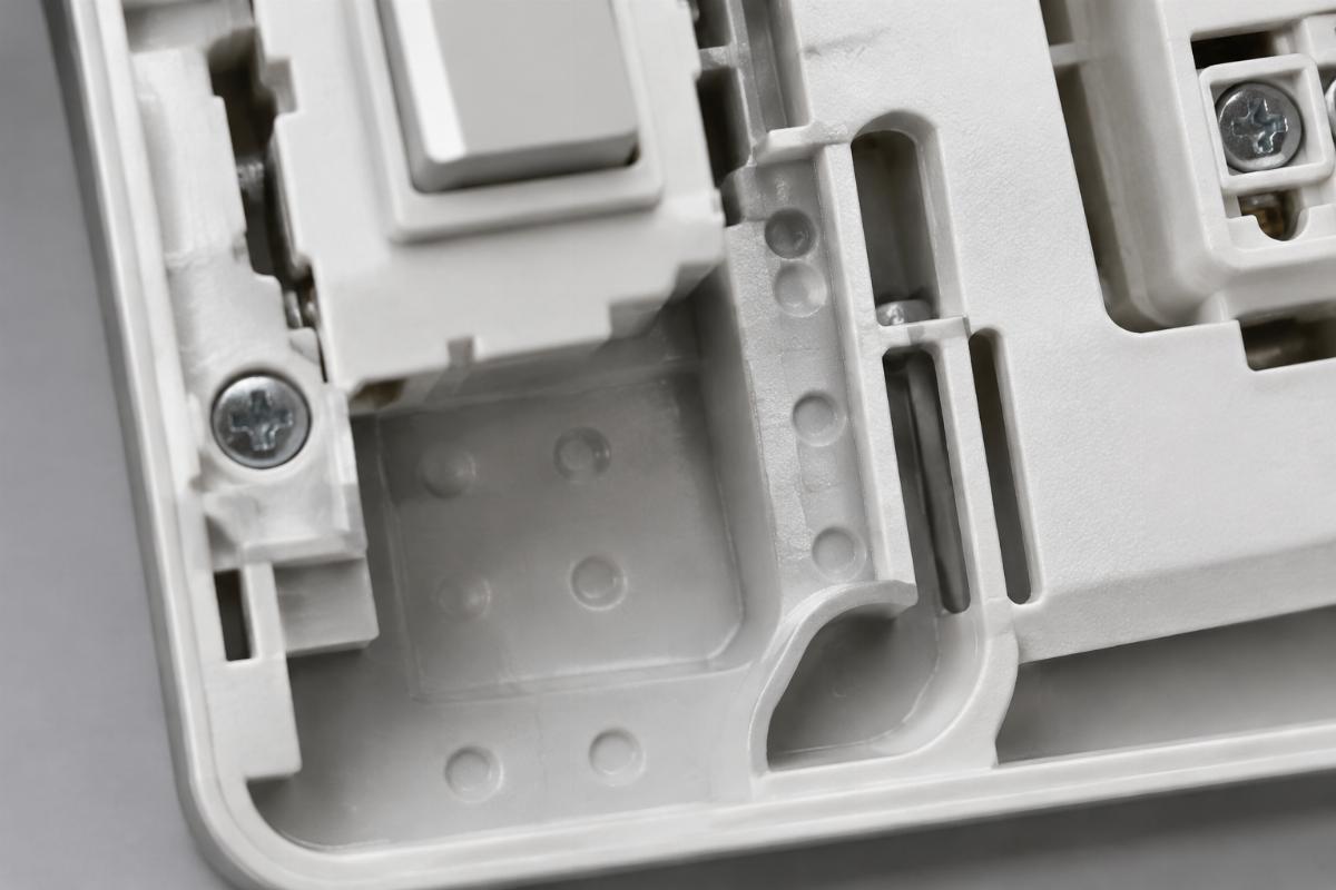 Close up of dimpled and slotted switch housing area for internal wiring routing