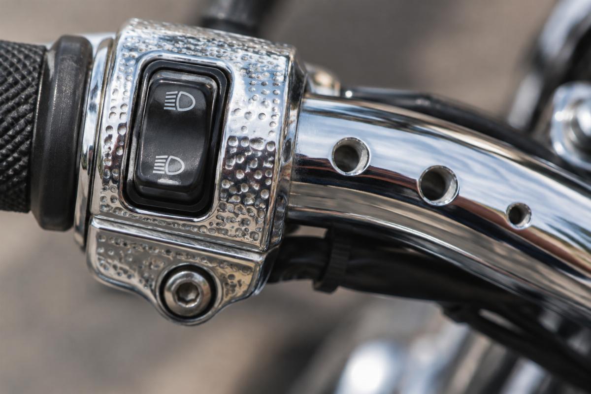 Close up of dimpled switch area and drilled holes on chrome handlebars