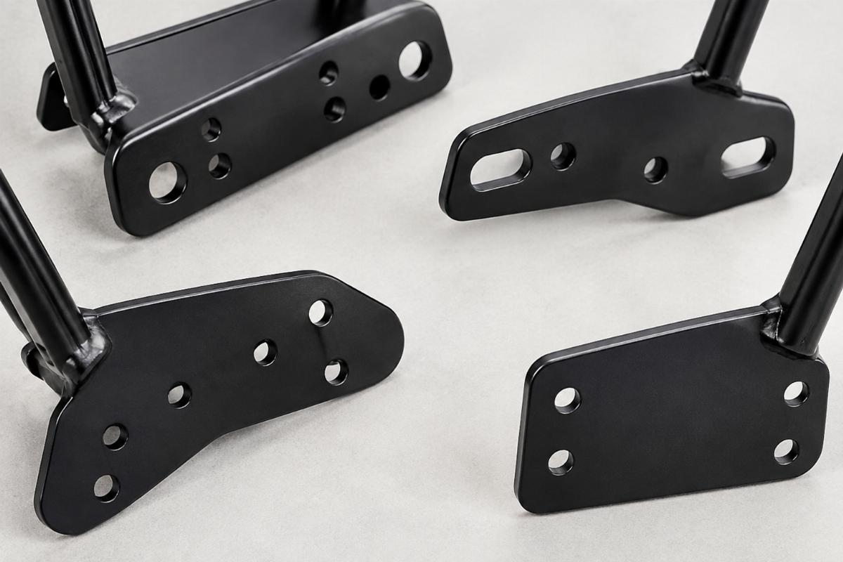 Close up view of different sissy bar base plates showing varying bolt hole patterns