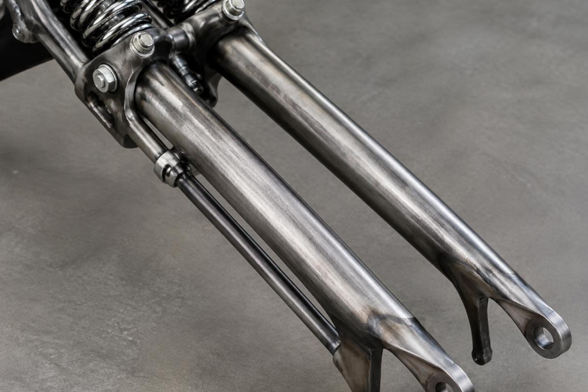 Detail of raw finish on spring fork front leg tube set for custom springer